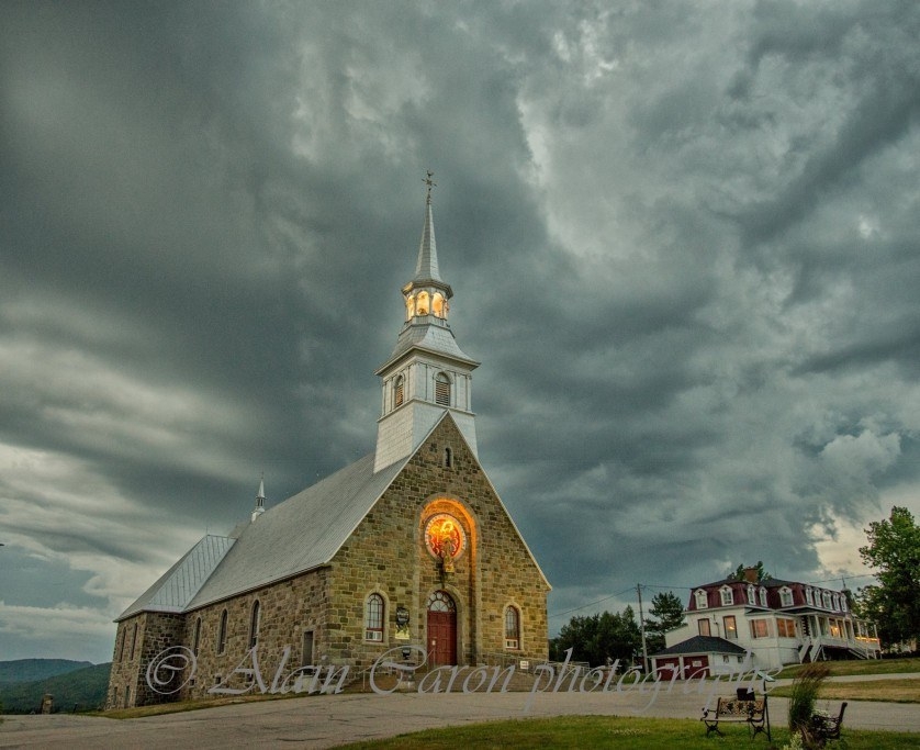 L'église des Éboulements sous un ciel orageux par Alain Caron